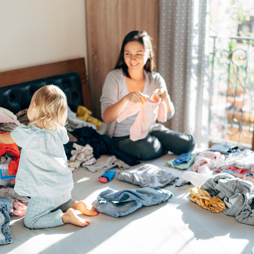 Woman and child play with socks in sunlit room, enjoying time without a smartphone