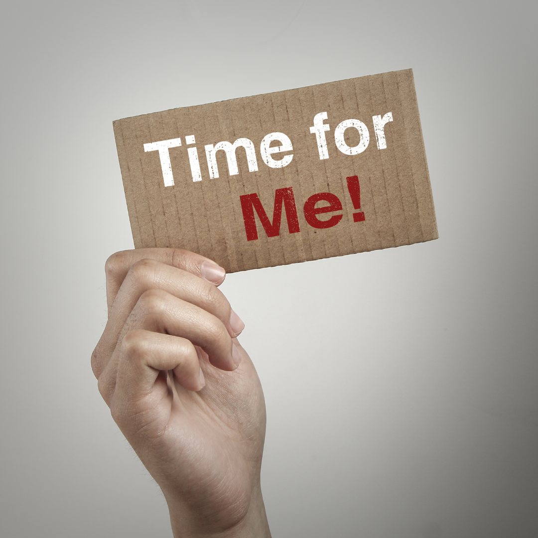 Human hand holding a sign with "Time for Me!" on a light gray background.