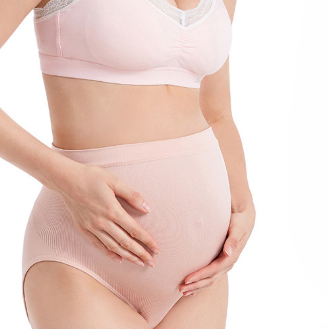 Person's hands on pink maternity wear, white background, no distractions