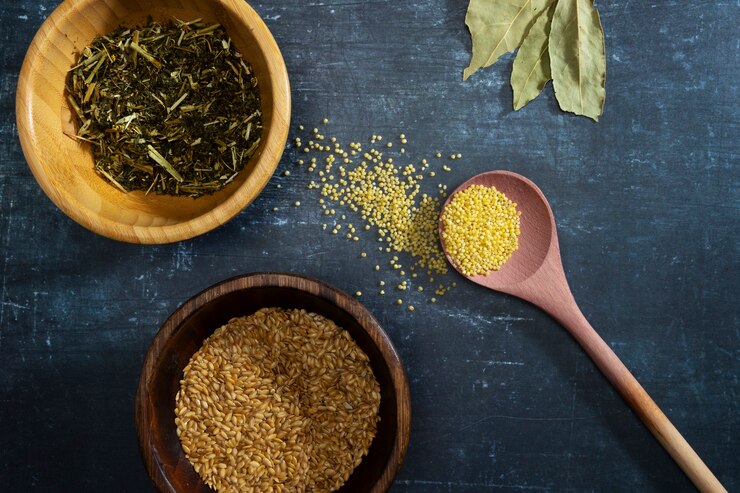 Breastfeeding accessories with natural grains, seeds, and a wooden spoon on blue surface