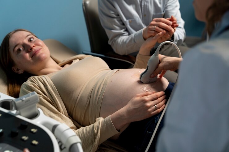 Woman relaxes during ultrasound in hospital; doctor ensures consent in pregnancy