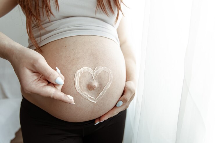 Maternal empowerment expressed through heart symbol on a pregnant belly.