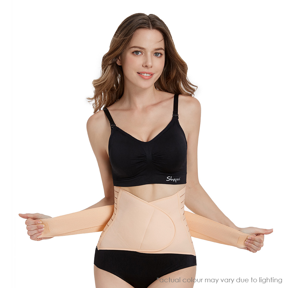 Woman showcasing beige belly wraps, black sports bra, and underwear on white background