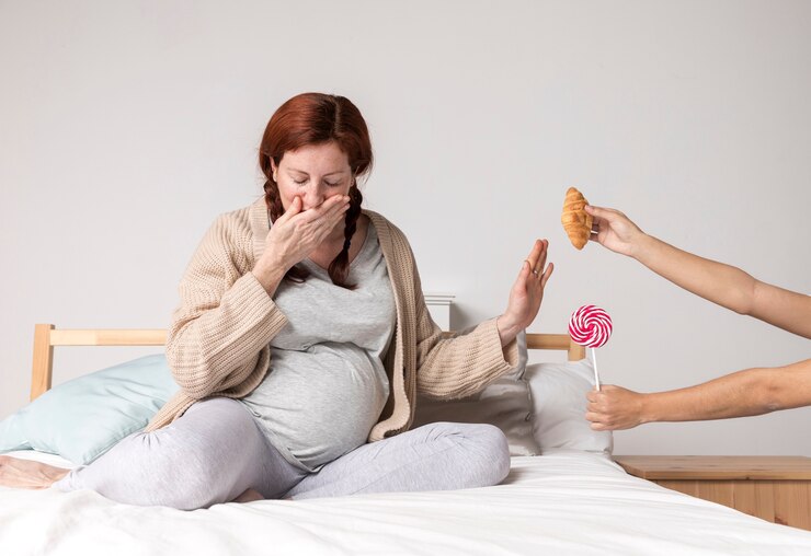 Woman with red hair on bed showing early pregnancy signs, refusing snacks